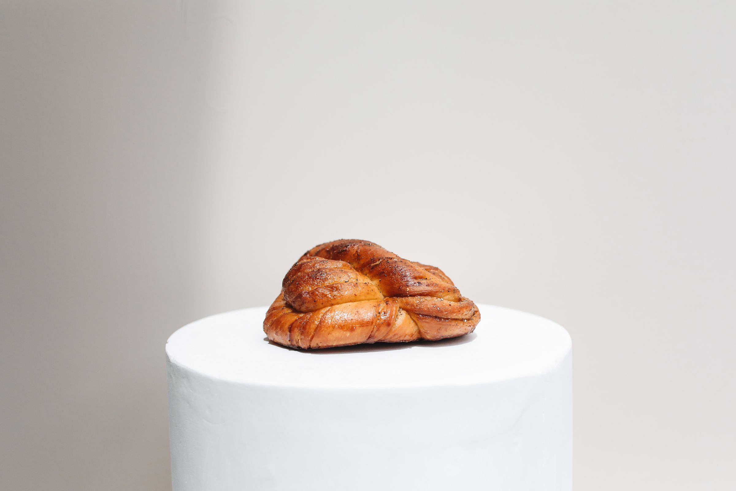 En kardemummaknut på ett vitt podium mot en ljus vägg.